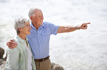 Image showing Senior, couple and point at beach with smile for retirement vacation or anniversary to relax with love, view and commitment with support. Elderly man, woman and together by ocean for peace on holiday