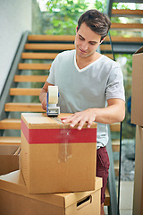 Image showing Man, packing and box in home for moving with investment in real estate, new house and tape for package safety. Person, happiness and cardboard by stairs for storage, cargo or relocating from property