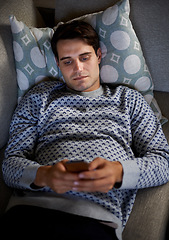 Image showing Home, night or above of man on a phone for social media blog, post or network on a sofa. Streaming movie, mobile app or person online for texting on technology for article, email or news to relax