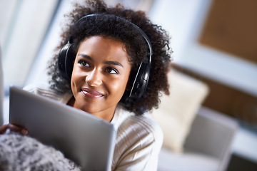 Image showing Headphones, tablet and happy woman in home lounge, streaming and movies for entertainment. Relax, weekend and technology for social media, communication and online scrolling, African female leisure