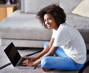 Image showing Smile, laptop and portrait of woman on floor working on freelance creative project in living room. Happy, technology and African female designer typing on computer for research on rug in apartment.