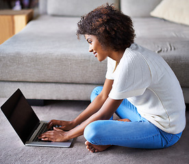 Image showing Smile, laptop and black woman on floor working on freelance creative project in living room. Happy, technology and young African female designer typing on computer for research on rug in apartment.