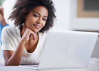 Image showing Reading, laptop and woman on sofa working on freelance creative project in living room. Relax, technology and young African female designer typing on computer for research on couch in apartment.