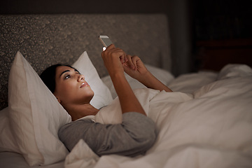 Image showing Woman, scrolling and phone for social media, bed and relaxation under blankets in pajamas to sleep. Female person, browse and tech for peace, night and online for conversation, chat and memes