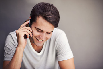 Image showing Man, happy and phone call for talking in studio for communication on mobile network by background. Person, smartphone and listen with smile for chat, story or contact for conversation with connection