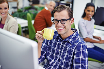 Image showing Man, smile and desk with coffee on computer in office, digital design for online research for business website. Colleague, career and employees for creative company, typing or browse on internet