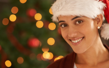 Image showing Woman, Christmas tree and portrait with santa hat, happy and pride for festive fashion in home living room. Girl, person and excited for xmas celebration by lights, ornaments or smile in house party