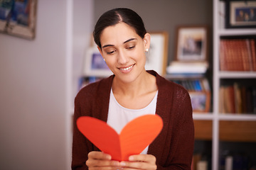 Image showing Woman, reading and heart letter in home for valentines day, memory and happy for celebration with sign. Girl, person and greeting card for love, kindness and note for relationship with smile in house