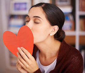 Image showing Woman, kiss and heart card in home for valentines day, memory and happy for celebration with sign. Girl, person and love letter for romance, kindness and notes for relationship with care in apartment