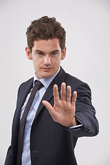 Image showing Businessman, hand and stop with sign for rejection, no or decline on a gray studio background. Young man, model or employee showing palm, gesture or symbol for wait, warning or refusal on mockup