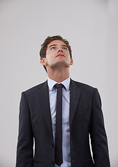 Image showing Businessman, thinking and looking up with dream on mockup for idea on a gray studio background. Isolated young man, model or employee in business suit, wonder or thought for career plan or mindset