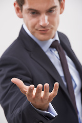 Image showing Businessman, palm and hand with interaction for hologram or virtual display on a gray studio background. Isolated young man, user or business employee showing gesture sign, symbol or 3D technology