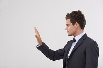 Image showing Businessman, palm and interaction with mockup space or virtual interface on a gray studio background. Isolated young man, model or profile of employee with hand touching display, interactive UI or UX