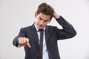 Image showing Businessman, confused and pointing with touch, UX or UI display on a gray background. Young man, user or employee in doubt with finger or interaction for virtual technology, push or click on mockup