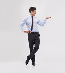 Image showing Businessman, palm and presentation with mockup space for advertising, choice or selection on a gray studio background. Young man or business employee with hand out for marketing, decision or pick