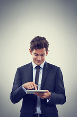 Image showing Tablet, research and business man scroll in studio isolated on gray background mockup space for communication. Digital technology, trader and happy professional, networking or reading email on app