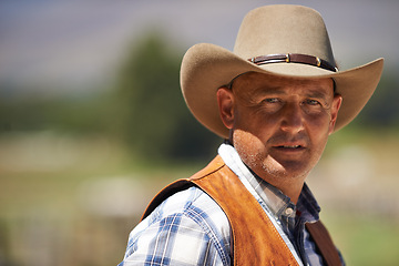 Image showing Portrait, confident cowboy and man at farm in the rural countryside for agriculture in Texas. Rancher, serious and face of male person in western hat outdoor in casual clothes in nature at stable