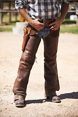 Image showing Farm, nature and legs of cowboy on ranch with weapon for horse, cows and rodeo animals for agriculture. Farming, costume and closeup of man in environment, countryside and working outdoors in Texas