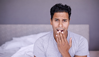 Image showing Man, yawn and tired in bedroom in portrait, fatigue and insomnia with sleep problem in morning. Young person, sleepy face or exhausted on break on lazy weekend, pyjamas or stress on bed in apartment