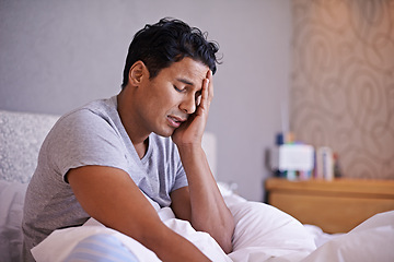 Image showing Man, sad and frustrated in bedroom with problem, disappointment and upset with mental health in morning. Young person, unhappy face and headache on weekend with depression and tired on bed in house