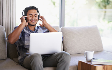 Image showing Man, headphones and laptop for music or website, home and internet for streaming sound. Happy male person, relax and song app on couch for audio or podcast, student and online for education to learn