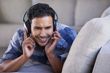 Image showing Man, headphones and listening to song on couch, relax and streaming radio for music or sound. Happy male person, home and lying on sofa for peace, comfortable and hearing jazz playlist on weekend