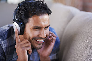 Image showing Man, headphones and listening to music on sofa, relax and streaming radio for audio or sound. Happy male person, home and lying on couch for peace, comfortable and hearing rock playlist on weekend