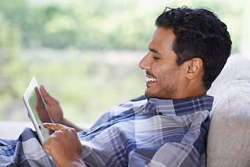 Image showing Man, tablet and living room with home, smile and internet for relax and streaming. Indian person, web and tech with house, lounge or apartment for watching video and connectivity with subscription