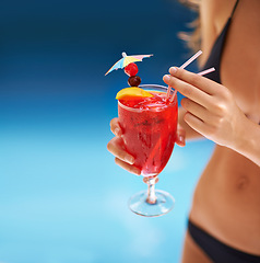 Image showing Cocktail, hand and woman in swimwear on vacation, weekend break and summer party in Fort Lauderdale. Person, glass and alcoholic drink in bikini for relax, peace and rest outdoor at holiday resort