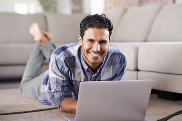 Image showing Man, freelancer and portrait for laptop on floor of living room, research and scroll or browse on web. Male person, happy and online for information or home for app, remote work and internet for plan