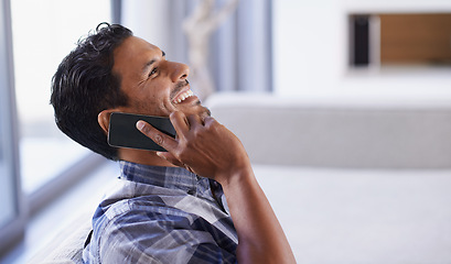 Image showing Man, smartphone and laugh on sofa for phone call, funny conversation and communication in living room. Indian person, relax and technology in apartment for discussion, joke and mobile contact