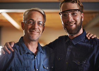 Image showing Man, hug and smile with portrait, workshop and family business or apprenticeship. Mature father, son and embrace with artisan, carpentry and together for startup and mentor or learning with happiness