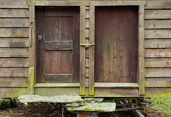 Image showing Time-worn wooden doors of a rustic countryside barn on a cloudy 