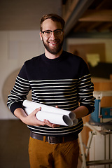 Image showing Portrait, architect and man with blueprint, renovation and entrepreneur in a workshop with construction. Face, property and employee with documents and maintenance with startup, smile and business