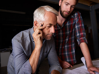 Image showing Architect, team and men with blueprint, thinking or plan for construction project with serious father teaching son. Engineer, apprentice and senior mentor with design for problem solving at workshop