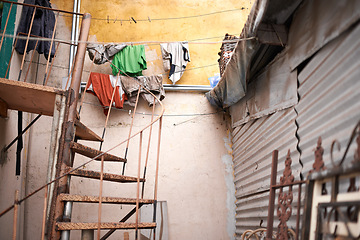 Image showing Stairs, outdoor and steel house with rust in zinc material with garbage at informal settlement or neighborhood in Brazil. Home, residential area and community with old or slum building in urban place