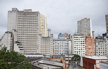 Image showing Cityscape, skyline and buildings in urban architecture with development, expansion and clouds in sky. City, metro and skyscraper with road, fog or winter morning on location with road in Sao Paulo