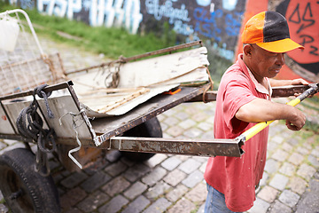 Image showing Man, walking and cart for trash in street for idea, strong or collect garbage for recycling for ecology. Person, rickshaw or wheelbarrow for favela, sustainability or environment on road in Sao Paulo