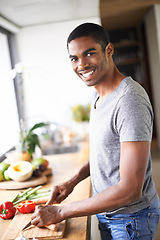 Image showing African, man and kitchen cooking and chopping, smiling and relaxed happy morning at counter. Confident and male person, food and culinary in apartment, nutrition and organic vegetable for breakfast
