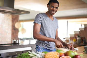 Image showing Man, fruit and vegetables with knife in portrait for cooking, salad and happy in home kitchen. African person, smile and pride with food, nutrition and vegan diet for health, wellness and meal prep