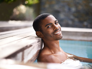 Image showing Portrait, pool and water with African man smiling, vacation and holiday outdoors to relax in sunshine. Summer, swimming and happiness for body wellness, calm person and weekend entertainment