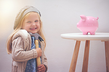 Image showing Girl, hammer and piggy bank for savings in portrait, finance and investment for future in home. Female person, child and waiting for profit or wealth, happy and tool to break a money box to spend