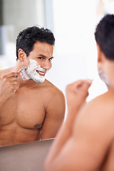 Image showing Hair removal, man and shaving foam on face in bathroom mirror for grooming, morning routine and razor. Smile, skincare and male person for wellness, facial treatment or cosmetics with reflection.