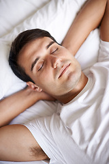 Image showing Man, sleep and bed for peace, wellness and rest for indoor in pajamas and bedroom for home and happy. Male person, relax and dreaming at house, calm and tired and eyes closed in top view nap