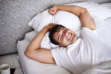 Image showing Man, sleep and bed for stretch, wellness and happy for rest in pajamas and bedroom for home and joyful. Male person, relax and dreaming at house, calm and tired in sleepwear and taking nap and smile