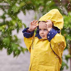 Image showing Happy, boy and rain jacket in winter with thinking for carefree, childhood and enjoyment in Germany. Kid, smile and wondering in nature for vacation, weekend or holiday travel in cold weather