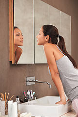 Image showing Bathroom, mirror and woman check face for skincare, beauty and wellness in morning routine. Health, dermatology and person in reflection for pimple, acne or cleaning, hygiene and grooming at home