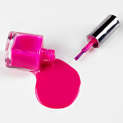 Image showing Nail polish, bottle spill and pink on a white background for beauty, cosmetics and salon products. Cosmetology, spa and isolated liquid, drip and paint for manicure, pedicure and pamper in studio