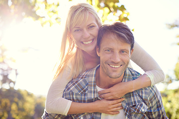 Image showing Couple, portrait and smile in park with piggyback for love together on vacation or nature explore, sunshine or relax. Man, woman and face for holiday in environment for date happiness, summer or trip