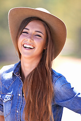 Image showing Portrait, fashion and smile of cowgirl on farm or ranch for agriculture or sustainability in summer. Countryside, texas or western with happy young person in hat outdoor in field for organic farming